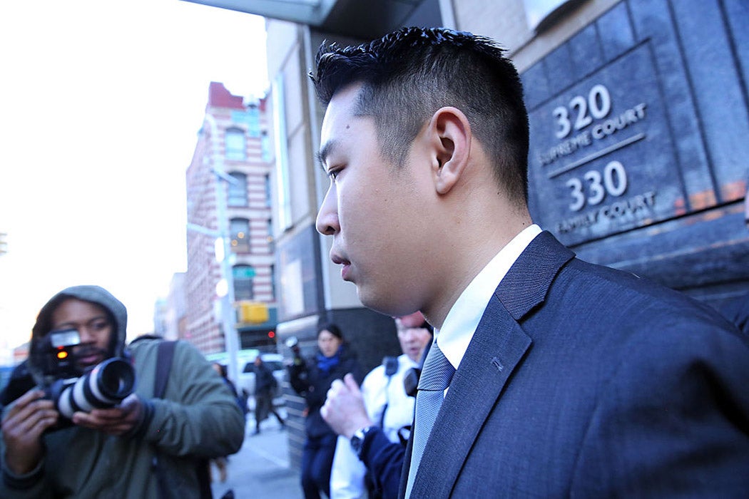 New York City police officer Peter Liang is escorted out of court after he was charged with manslaughter, official misconduct and other offenses on February 11, 2015 in the Brooklyn borough of New York City.
