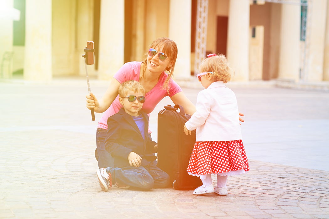 mother and kids taking selfie stick picture in Europe