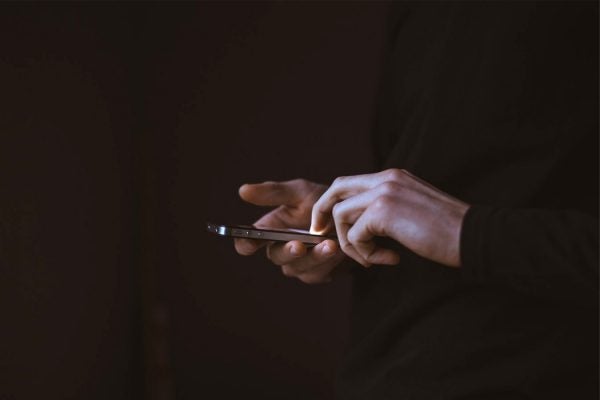 A person's hands holding an iPhone