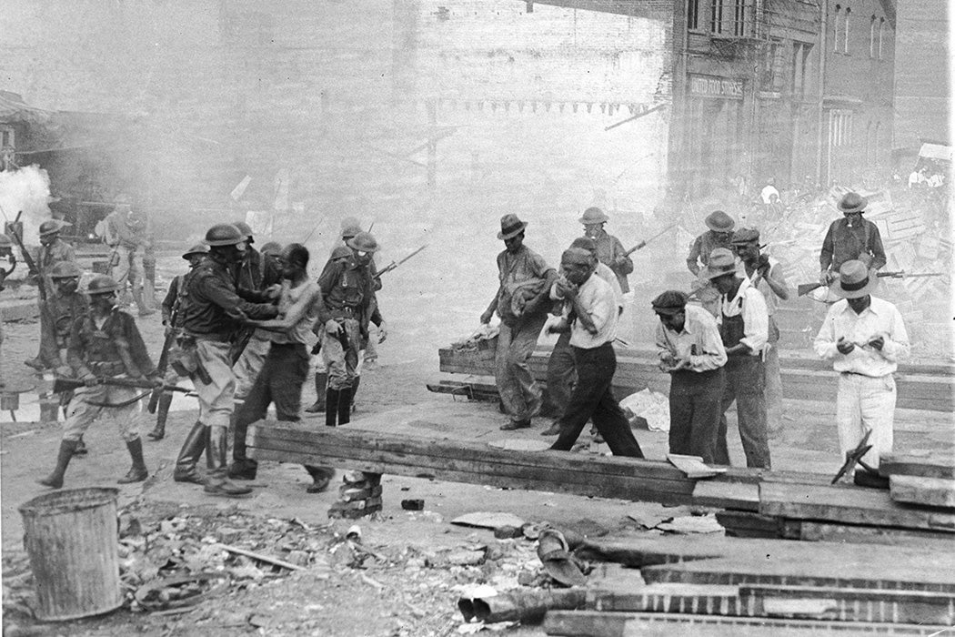 Soldiers in gas masks advance on World War I Bonus March demonstrators in Washington, D.C., July 1932.