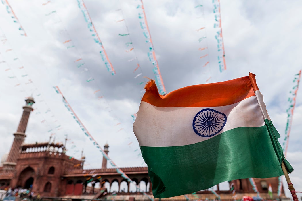 A tricolor India flag flies on top of a vehicle on the backdrop of the Jama Masjid mosque on August 15, 2022 in New Delhi, India.