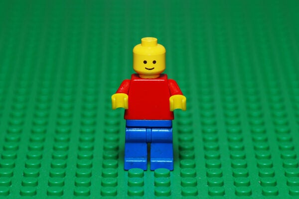 An old Lego character from the 80s on a green Lego surface.