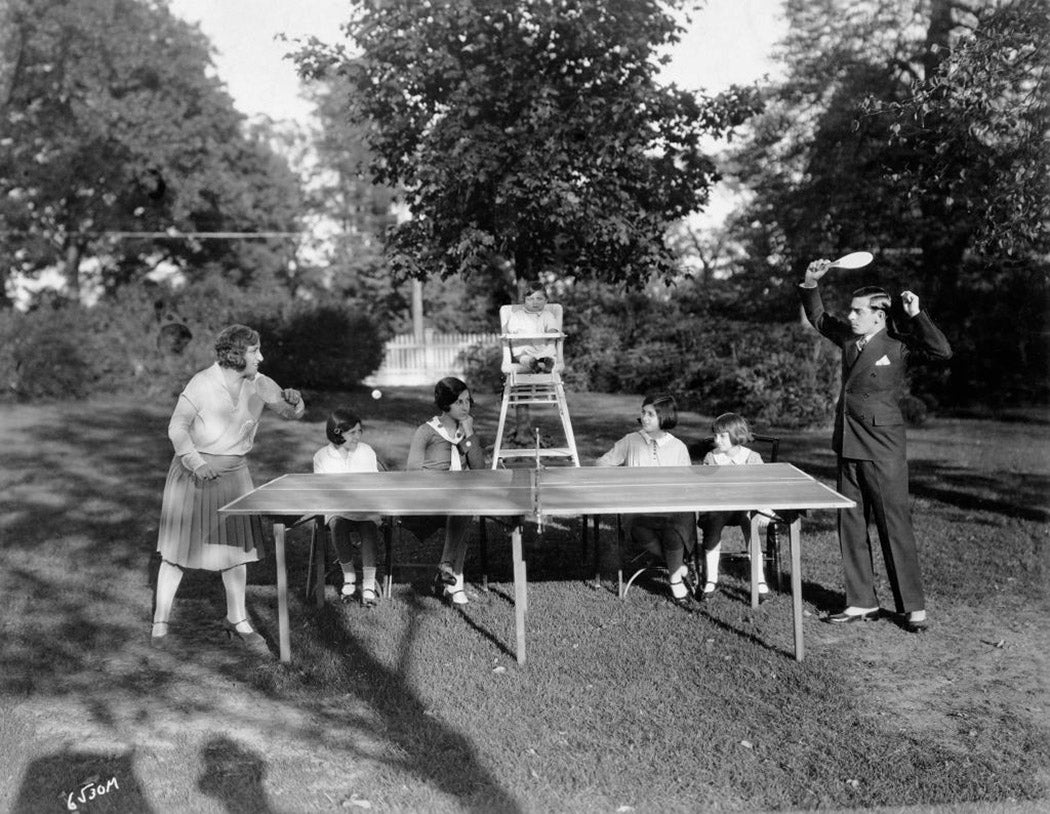 American actor, singer and comedian Eddie Cantor playing table tennis with his wife Ida and their family on the lawn of their new mansion in Long Island, circa 1925.
