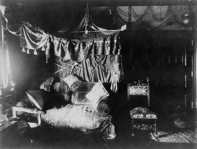 An exotic sitting room in the Hord residence, with a tented canopy, kilim rug, pillows, and an upholstered rocking chair. Click on the image to take a closer look.